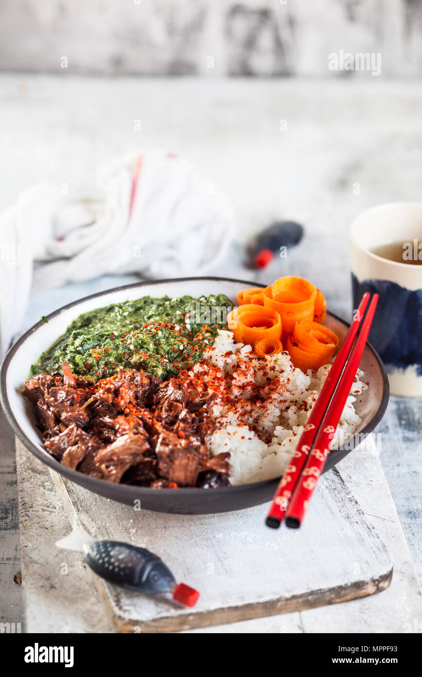 Vegan teriyaki bowl with pulled teriyaki beef made from jackfruit, spinach, rice and carrots Stock Photo