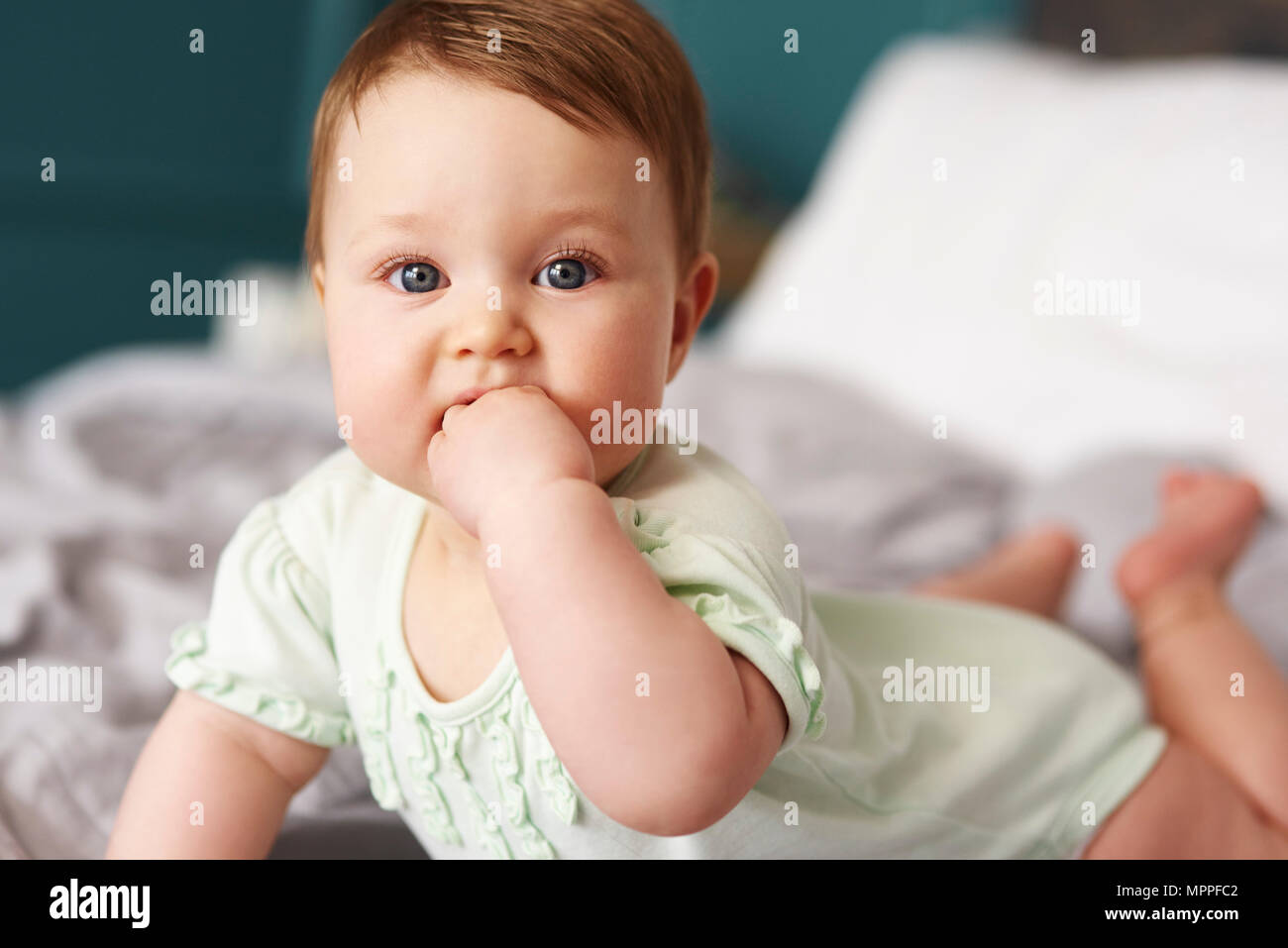 Portrait of baby lying on bed at home Stock Photo Alamy
