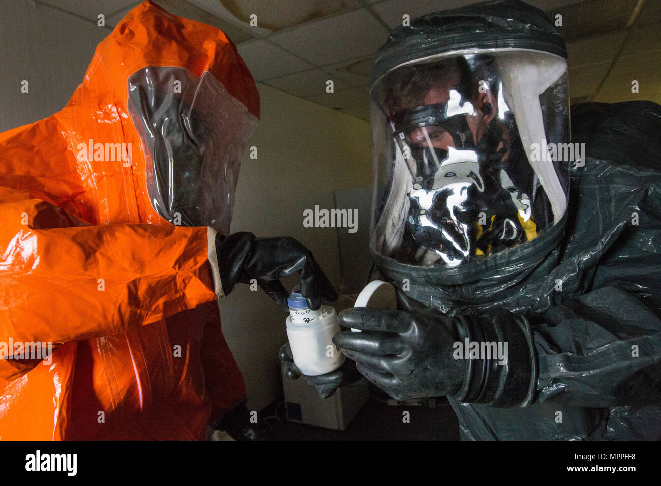 Sgt. Quran Williams, left, places a sample in an evidence container