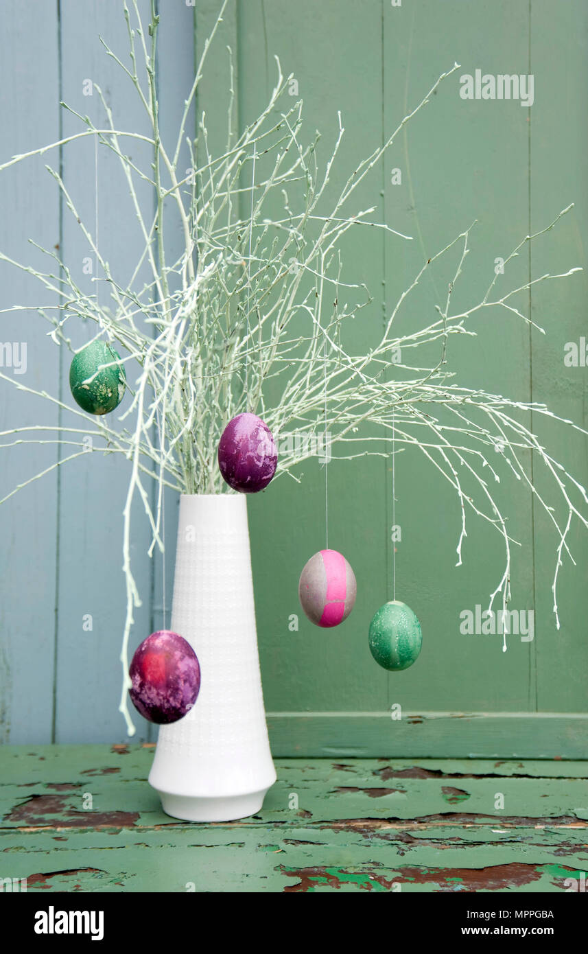 Sprayed twigs with dyed Easter eggs Stock Photo