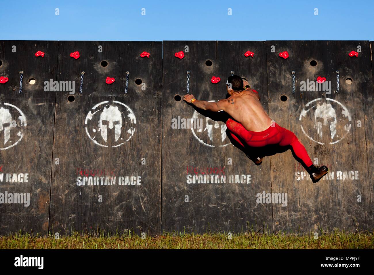 A Spartan Race competitor climbs an obstacle during a Spartan Race at the Best Ranger Competition 2017 in Fort Mitchell, Ala., April 8, 2017. The 34th annual David E. Grange Jr. Best Ranger Competition 2017 is a three-day event consisting of challenges to test competitor's physical, mental, and technical capabilities. (U.S. Army photo by Spc. Darius Davis) Stock Photo