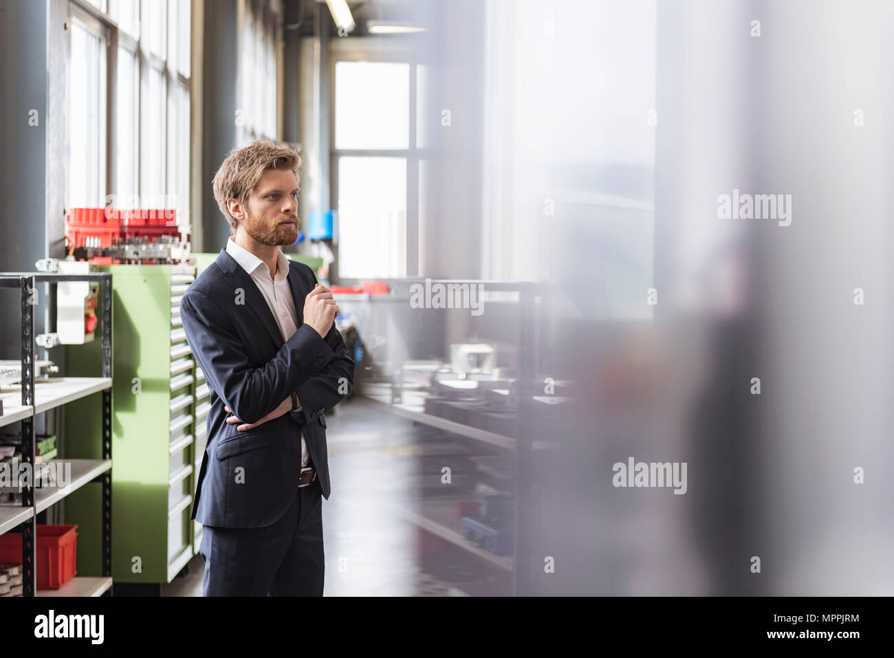 Businessman in modern factory staring Stock Photo