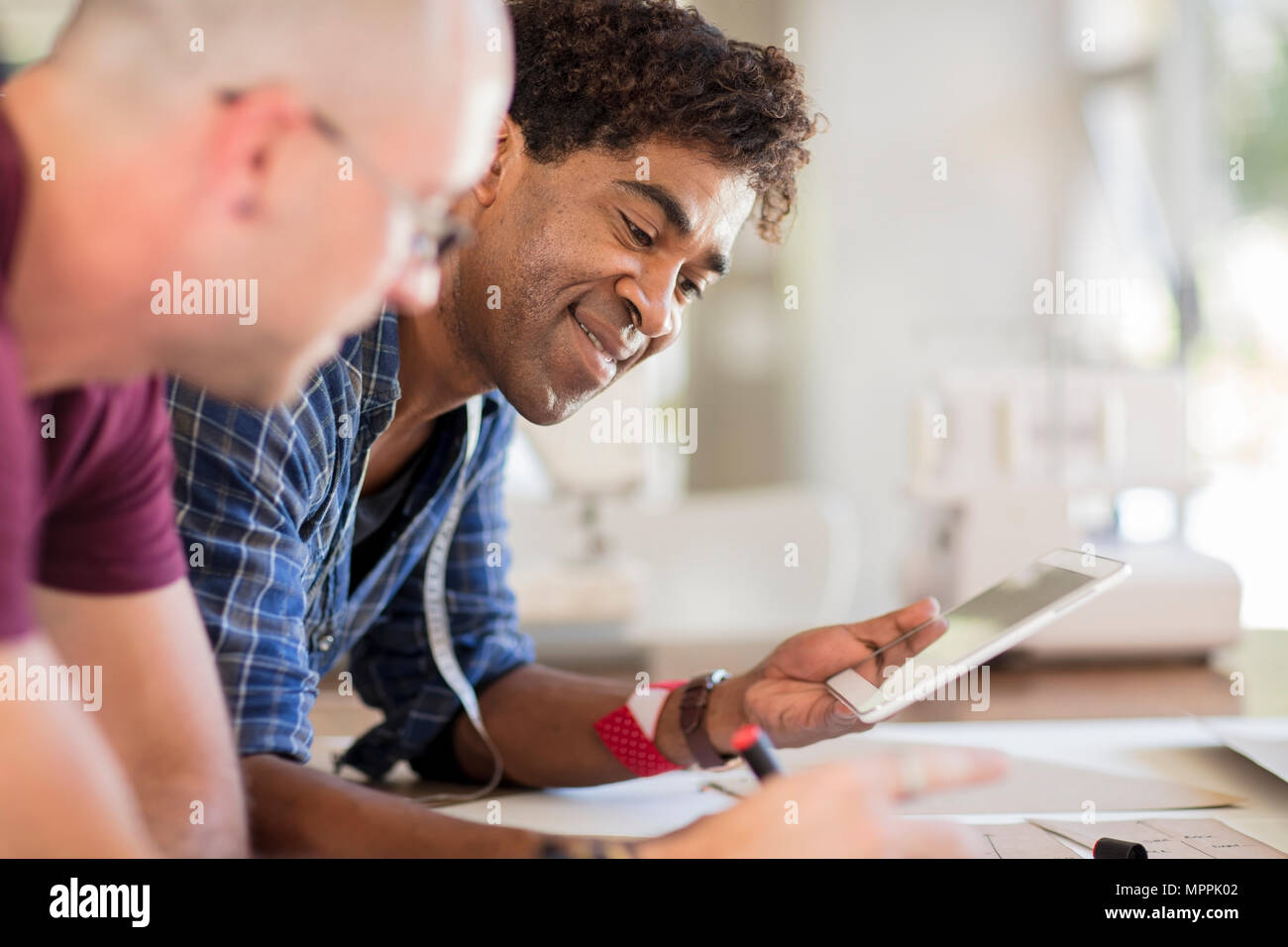 Two fashion designers using tablet in studio Stock Photo