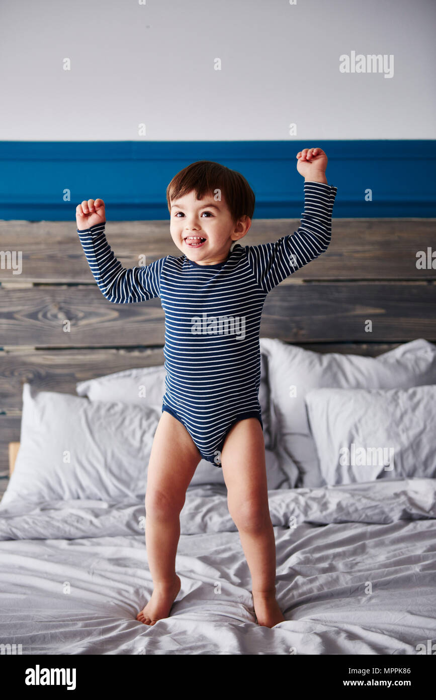 Portrait of happy toddler jumping on bed Stock Photo