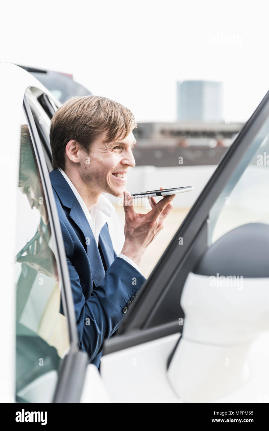 Smiling businessman using smartphone in car Stock Photo