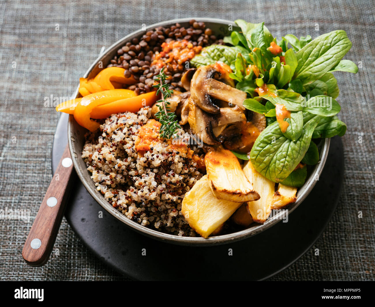 Lentil Quinoa Bowl, lentils, quinoa, bell pepper, roasted parsnips, field salad, mushrooms, spicy vegan sauce Stock Photo