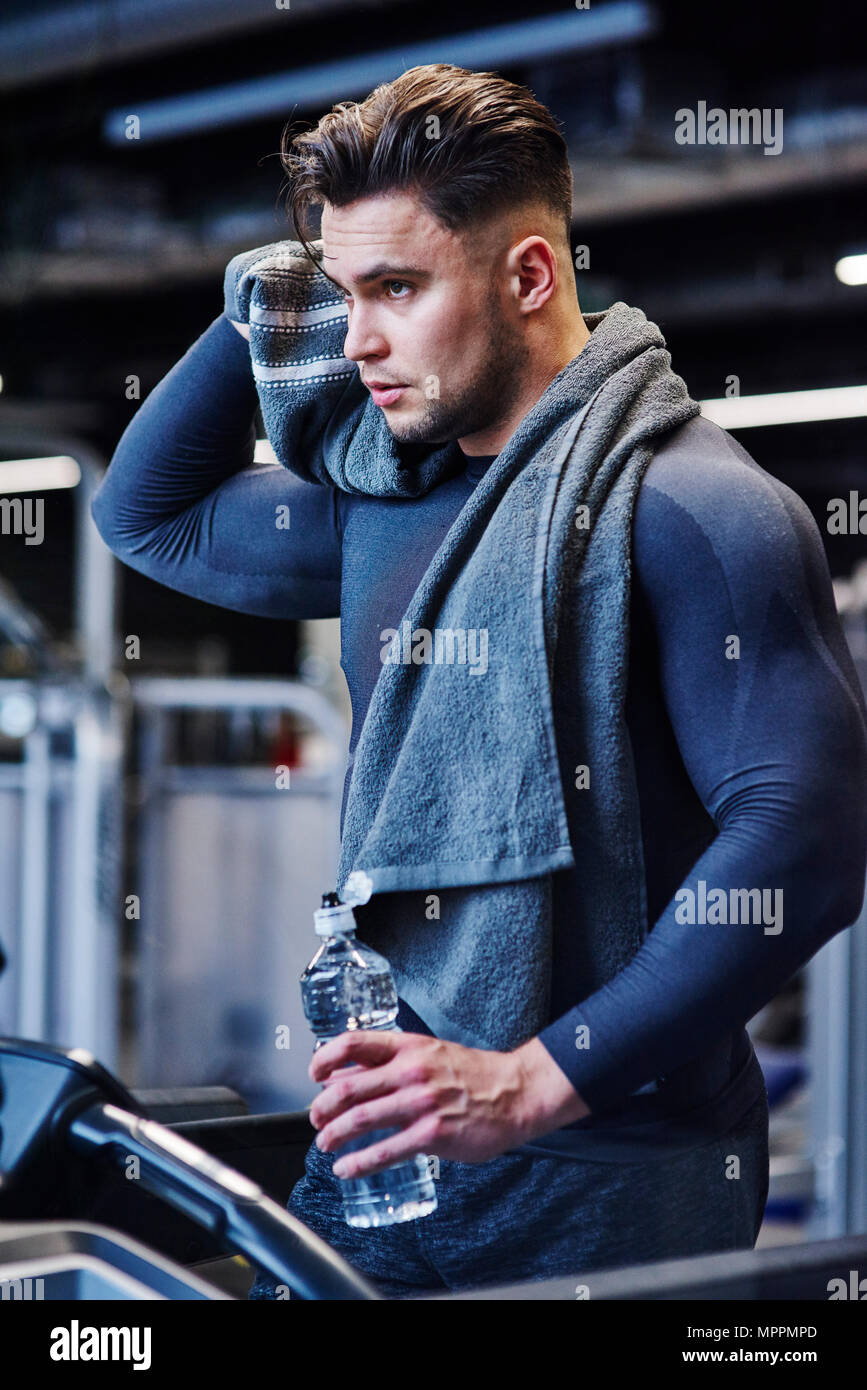 Man with bottle of water on a treadmill in gym Stock Photo - Alamy