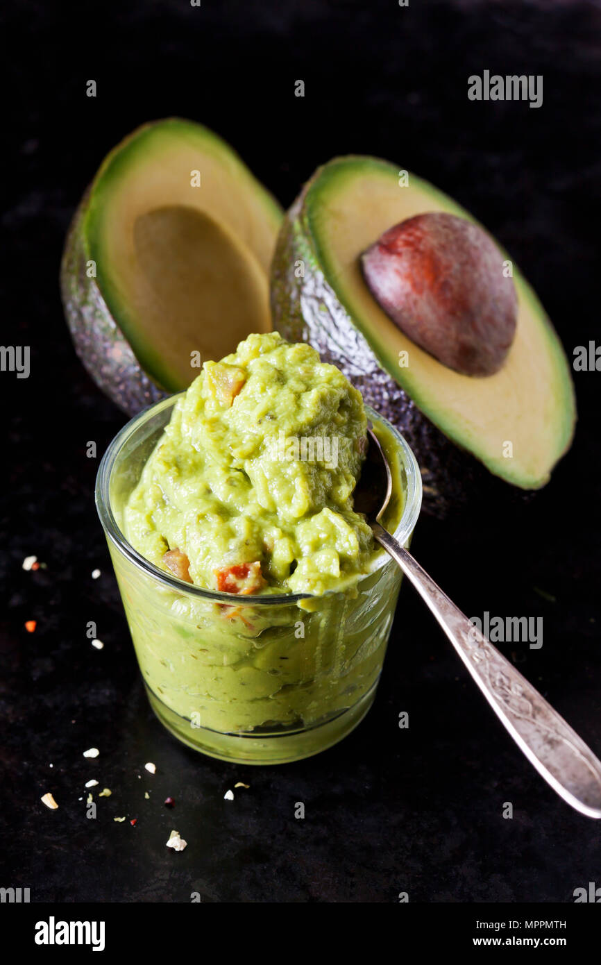 Glass of Guacamole and sliced avocado Stock Photo