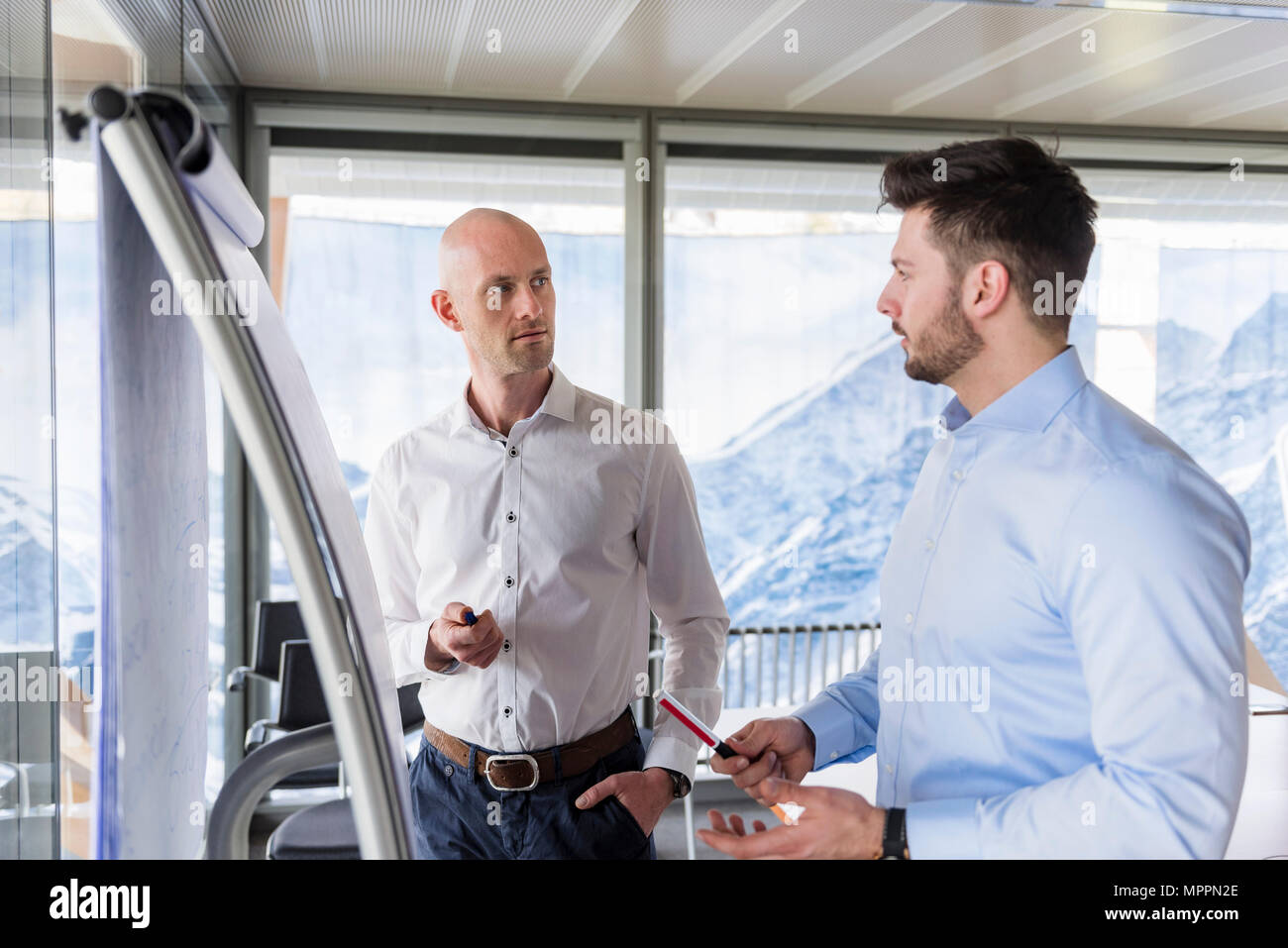 Two businessmen having a discussion at flipchart in office Stock Photo