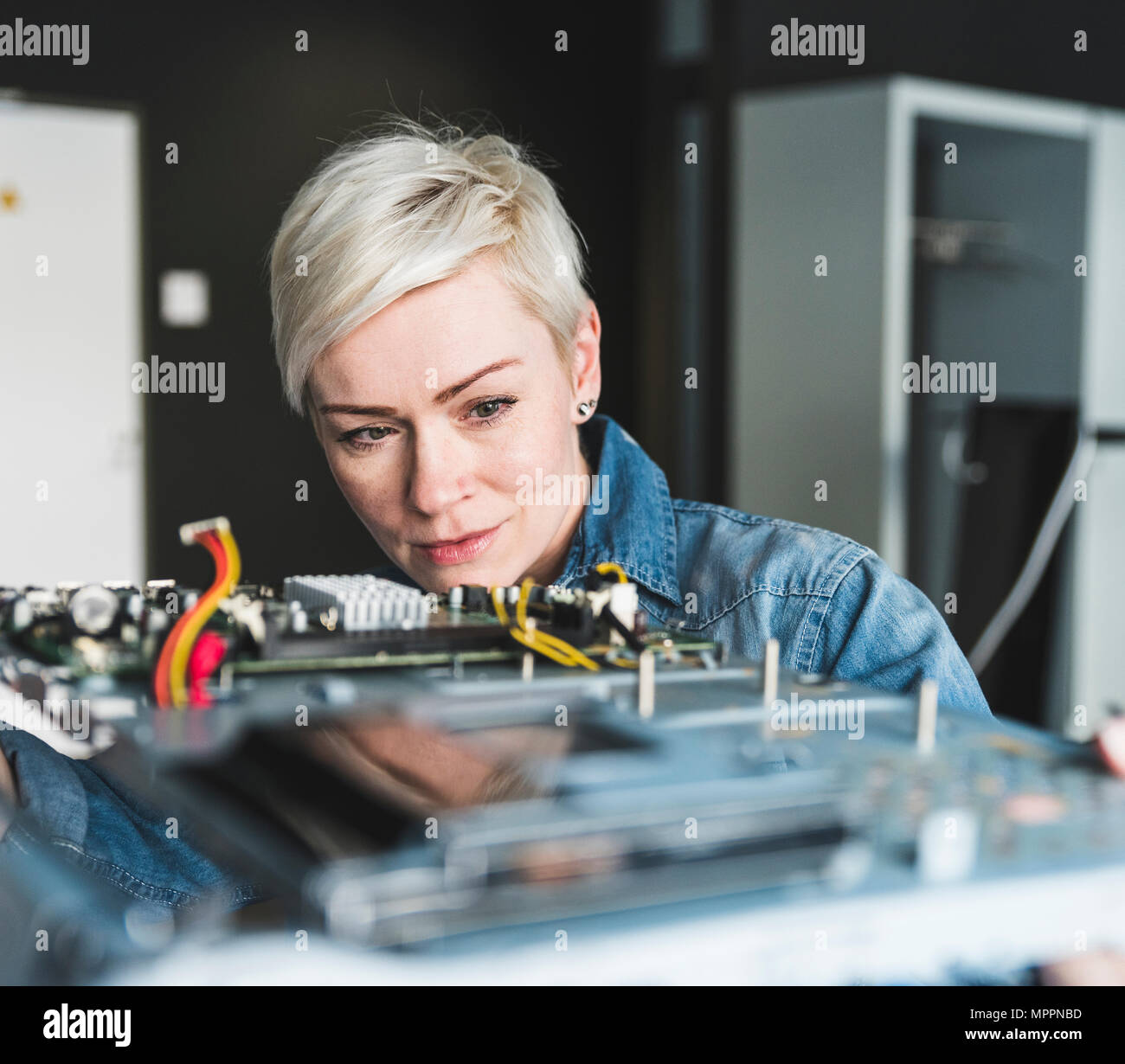 Woman examining computer equipment Stock Photo