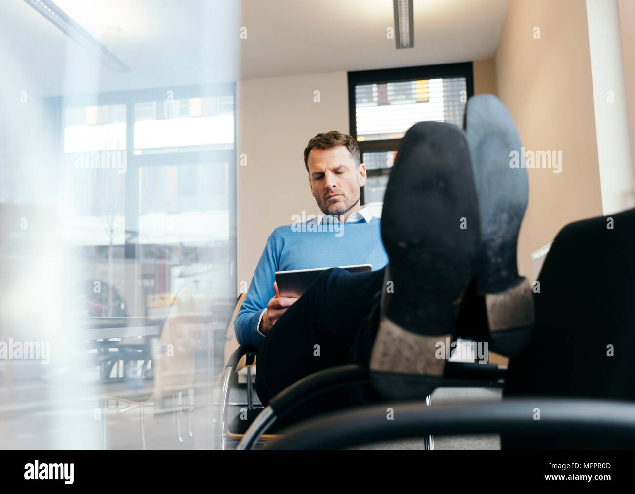Casual businessman using tablet in office Stock Photo