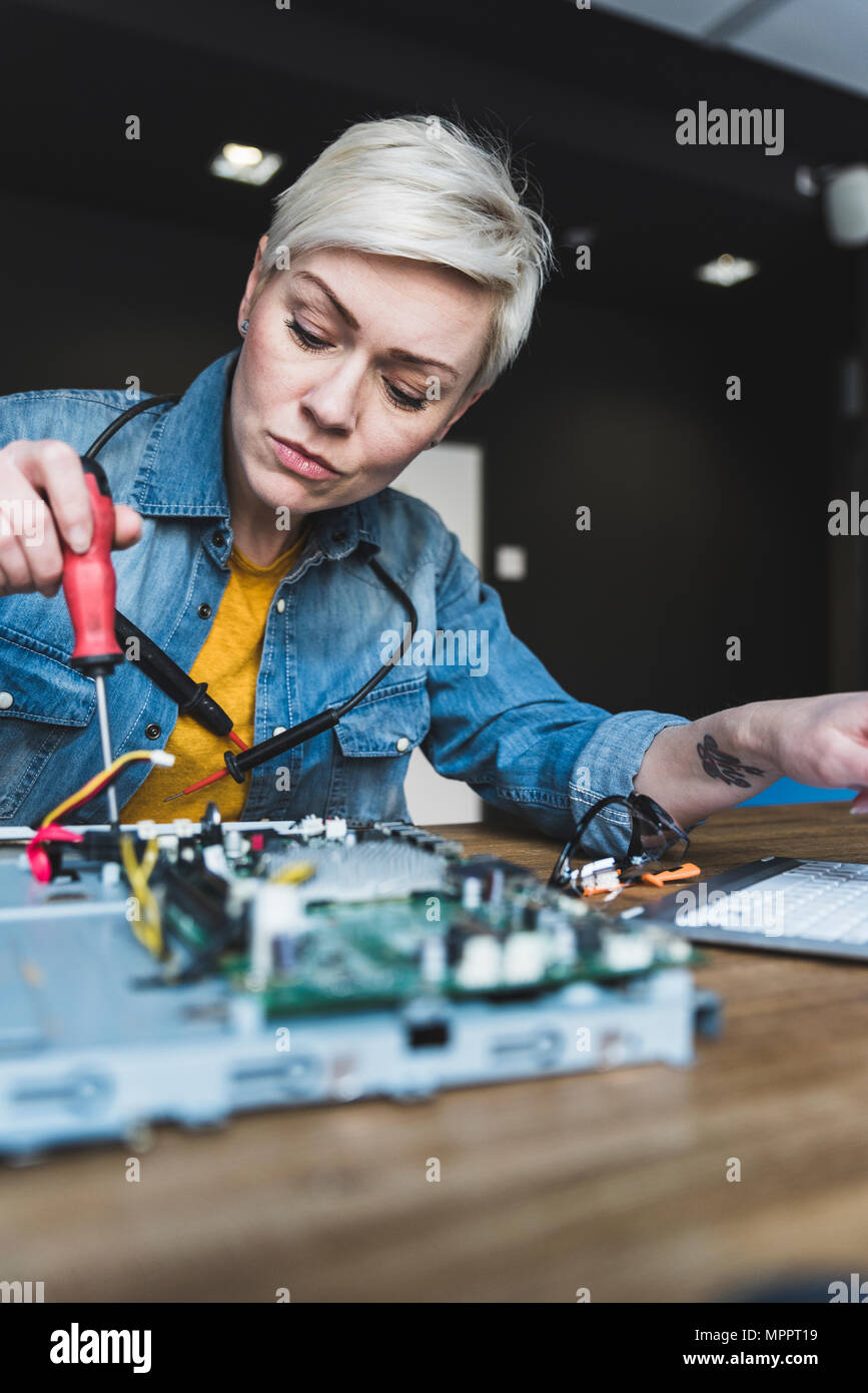 Woman working on computer equipment Stock Photo