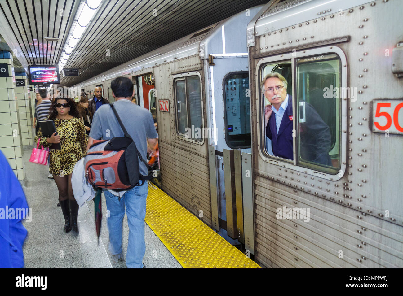 Toronto Canada,College Station,Yonge Yellow Line,TTC,Toronto Transit Commussion,subway,train,train,boarding,commuter,commuters,man men male,woman fema Stock Photo
