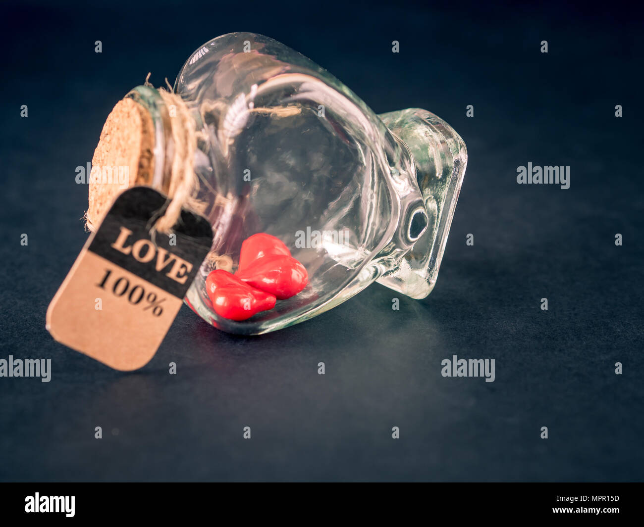 Retro red heart in shape bottle on black background. LOVE and valentine