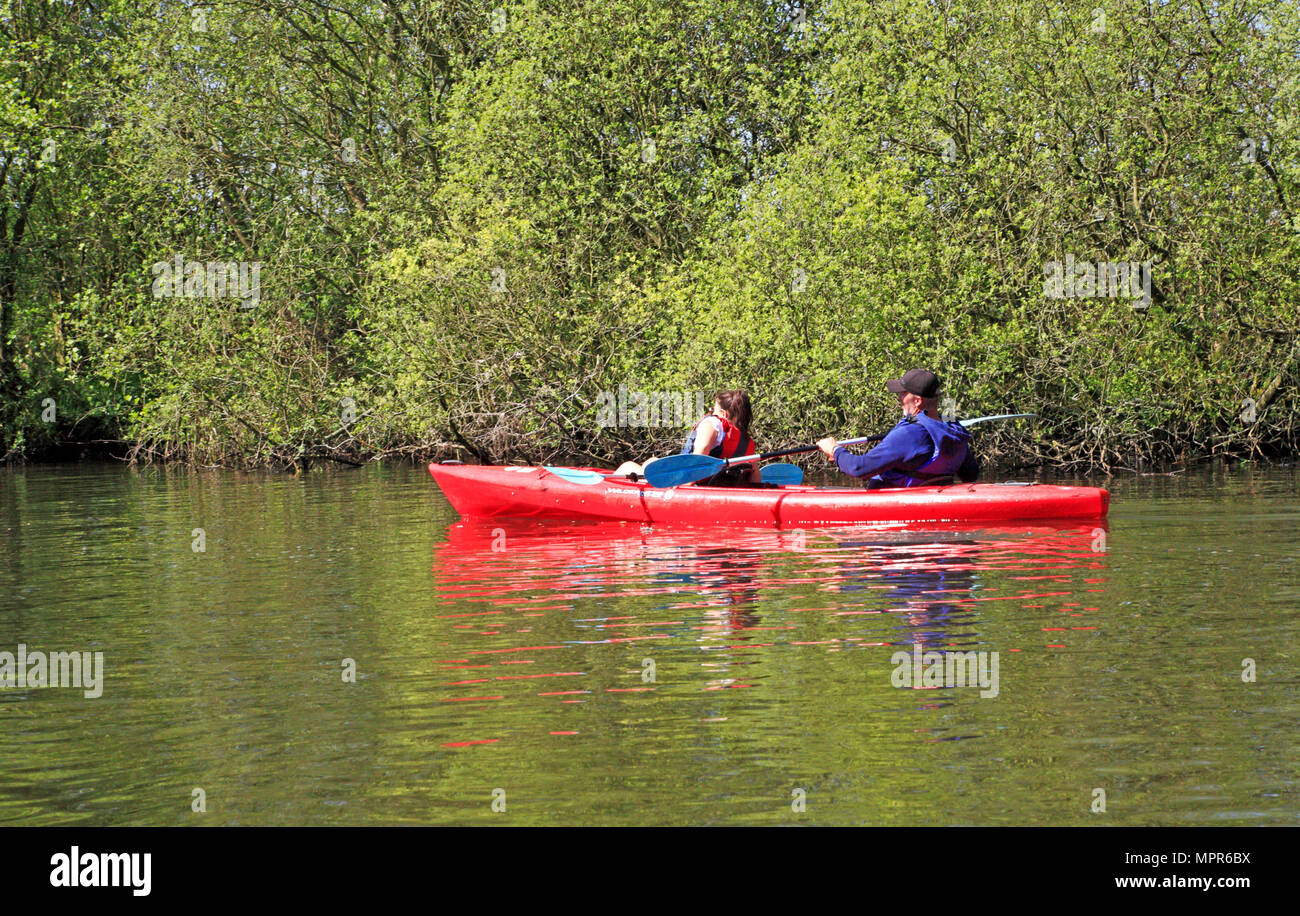 A couple making way in a red canoe on the River Bure on the Norfolk