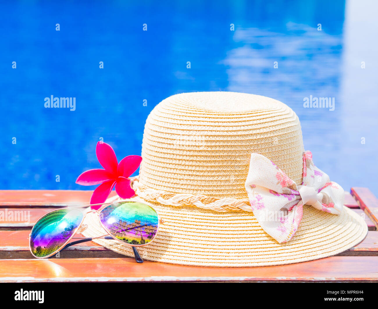 Red frangipani (plumeria) flowers with summer hat and sunglasses by the ...