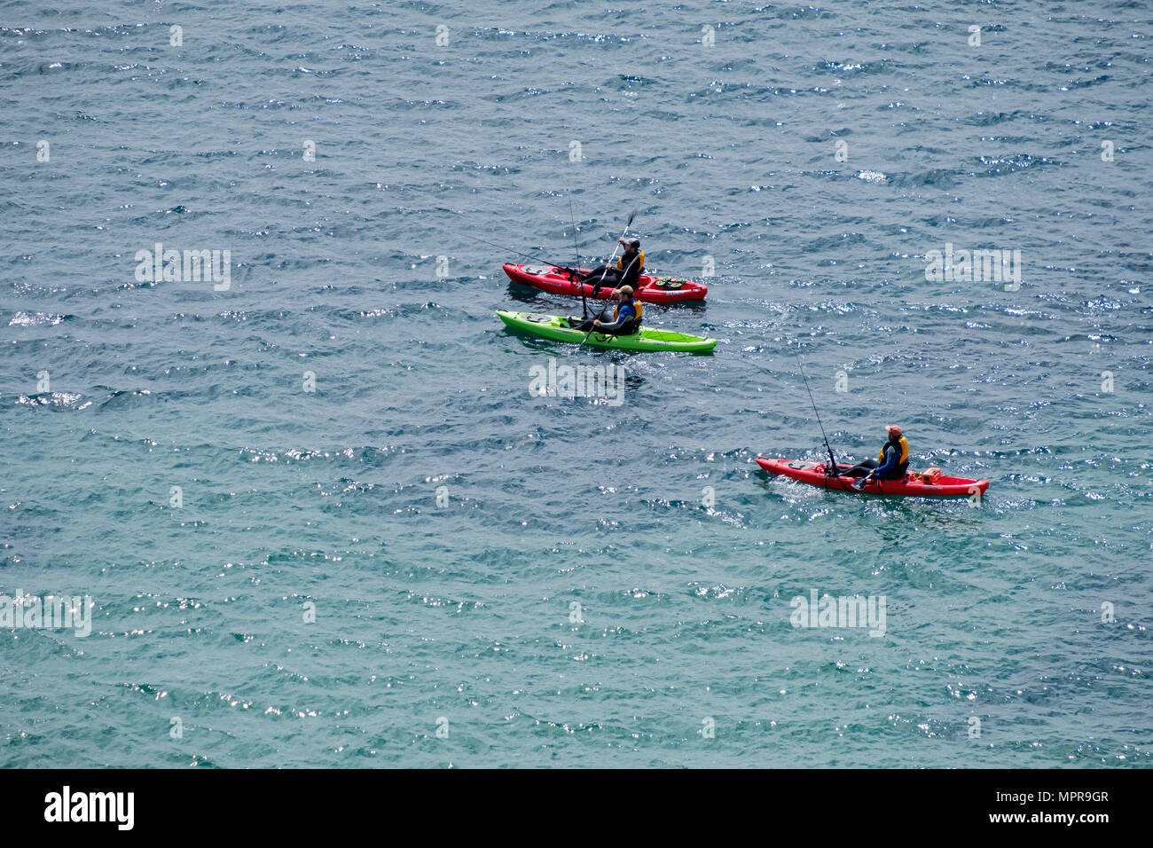MEN SEA FISHING FROM THREE CANOES IN SEA OFF LYDSTEP PEMBROKESHIRE WALES UK Stock Photo
