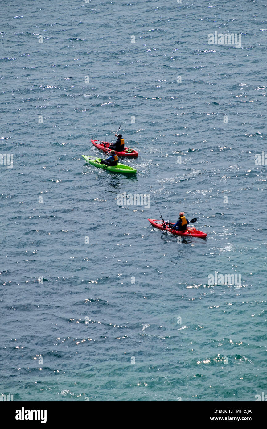 MEN SEA FISHING FROM THREE CANOES IN SEA OFF LYDSTEP PEMBROKESHIRE WALES UK Stock Photo