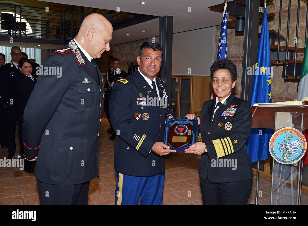 U.S. Army Col. Darius S. Gallegos, CoESPU deputy director (center), Italian Carabinieri Lt. Gen Vincenzo Coppola (left), Commanding General “Palidoro” Carabinieri Specialized and Mobile Units receive gift from Admiral Michelle Howard (right), NATO JFC-Naples Commander during the visit at the Center of Excellence for Stability Police Units (CoESPU) Vicenza, April 10, 2017. (U.S. Army Photo by Visual Information Specialist Paolo Bovo/released) Stock Photo