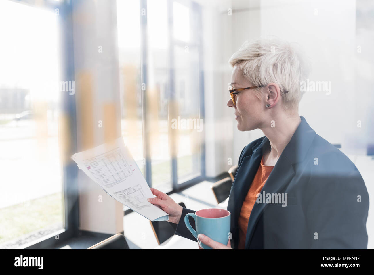 Businesswoman reading document in office Stock Photo