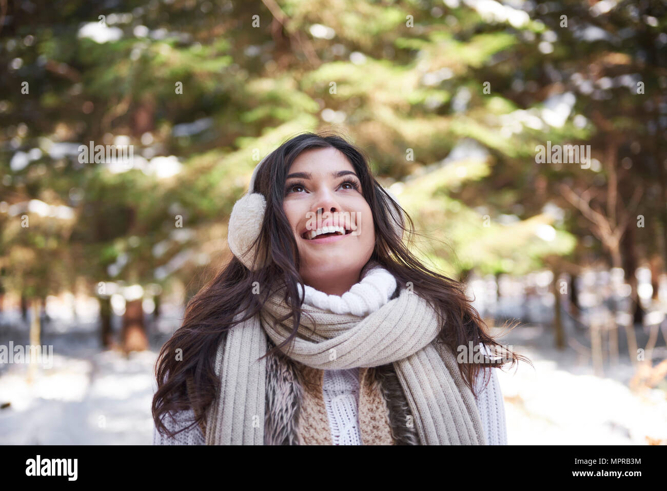 Portrait of happy young woman in winter forest Stock Photo