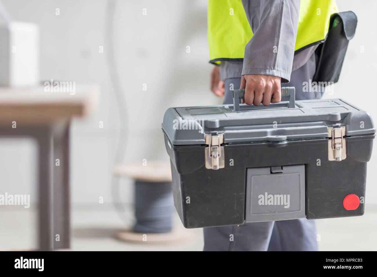 Close-up of construction worker carrying tool box Stock Photo