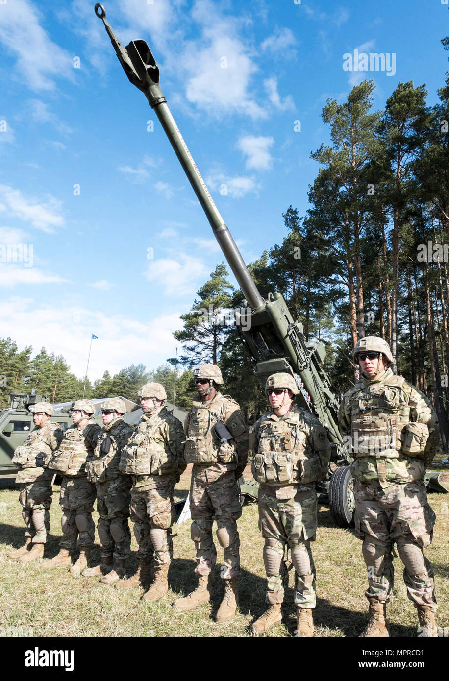U.S. Army Soldiers stand by their howitzer static display during rehearsal for Battle Group Poland's welcome ceremony scheduled for April 13 near Orzysz, Poland.  The unique, multinational battle group, comprised of U.S., U.K., Romanian and Polish soldiers, will serve as a deterrence force in northeast Poland in support of NATO's Enhanced Forward Presence. Stock Photo