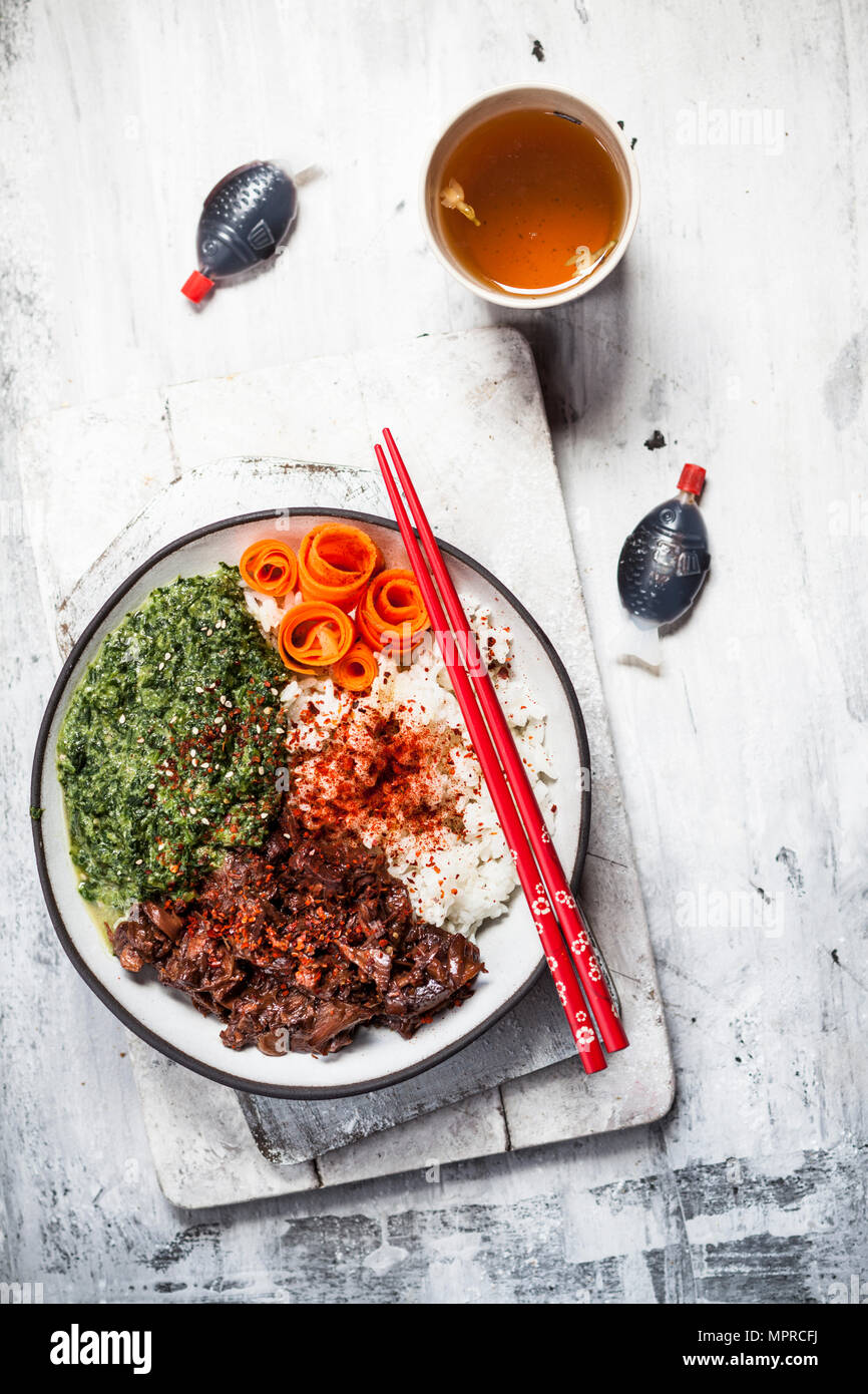 Vegan teriyaki bowl with pulled teriyaki beef made from jackfruit, spinach, rice and carrots Stock Photo