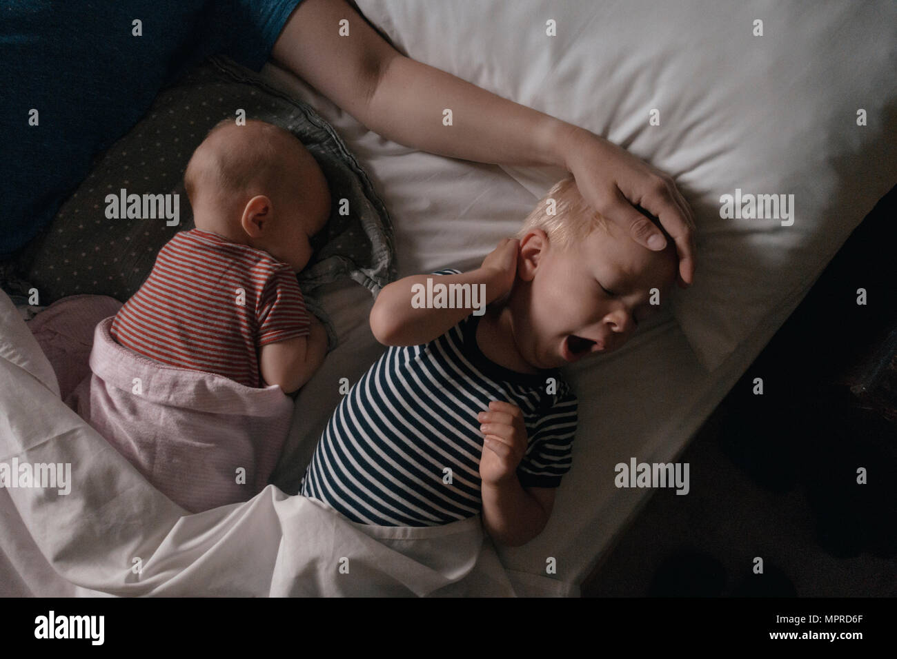 Vater lying next to his daughter and son in bed Stock Photo
