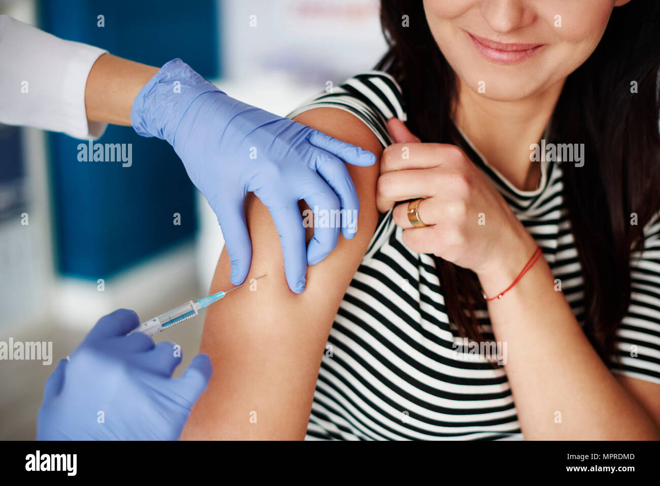 Woman receiving an injection in her arm Stock Photo
