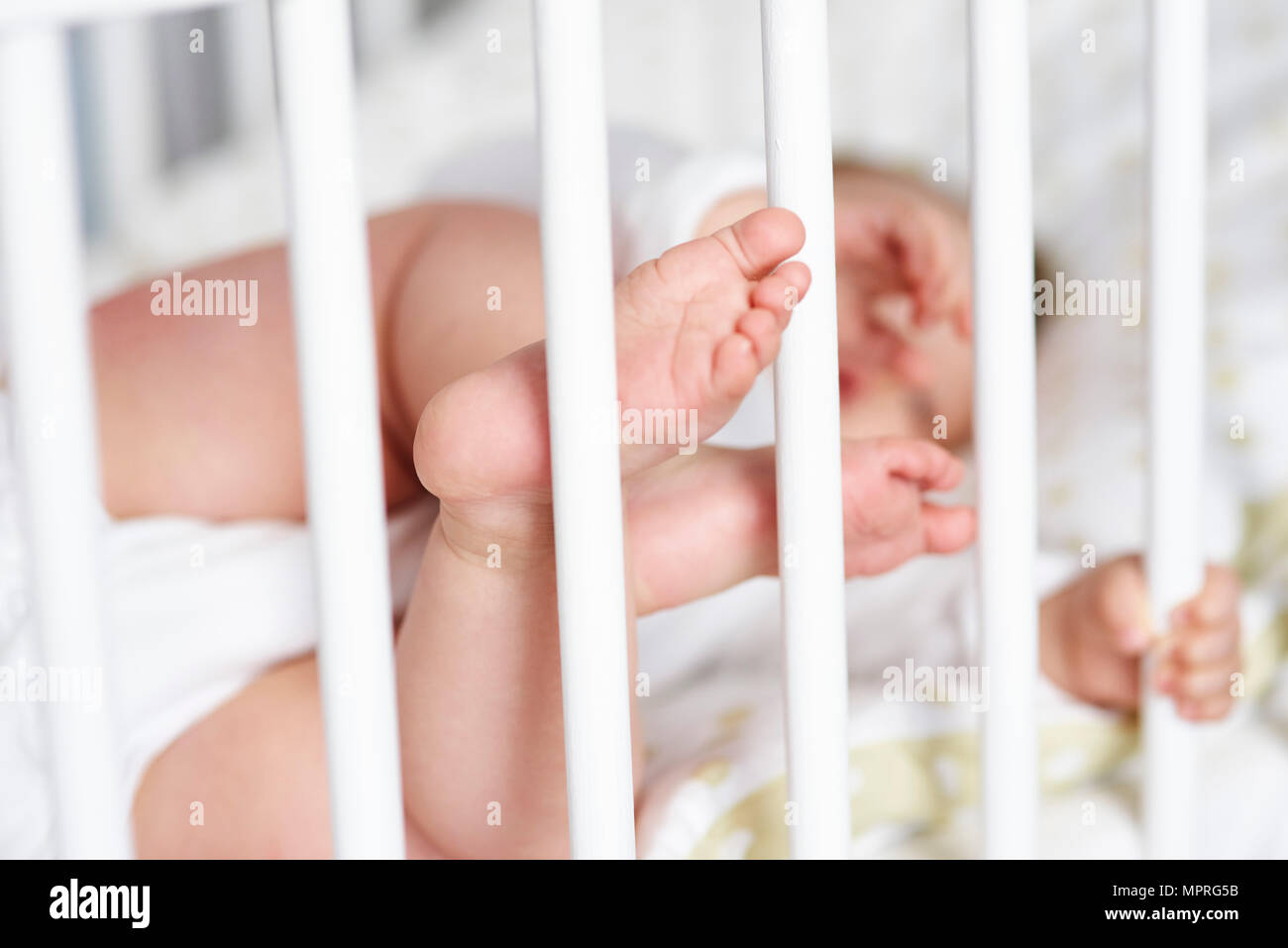 Close-up of tiny baby's feet in crib Stock Photo
