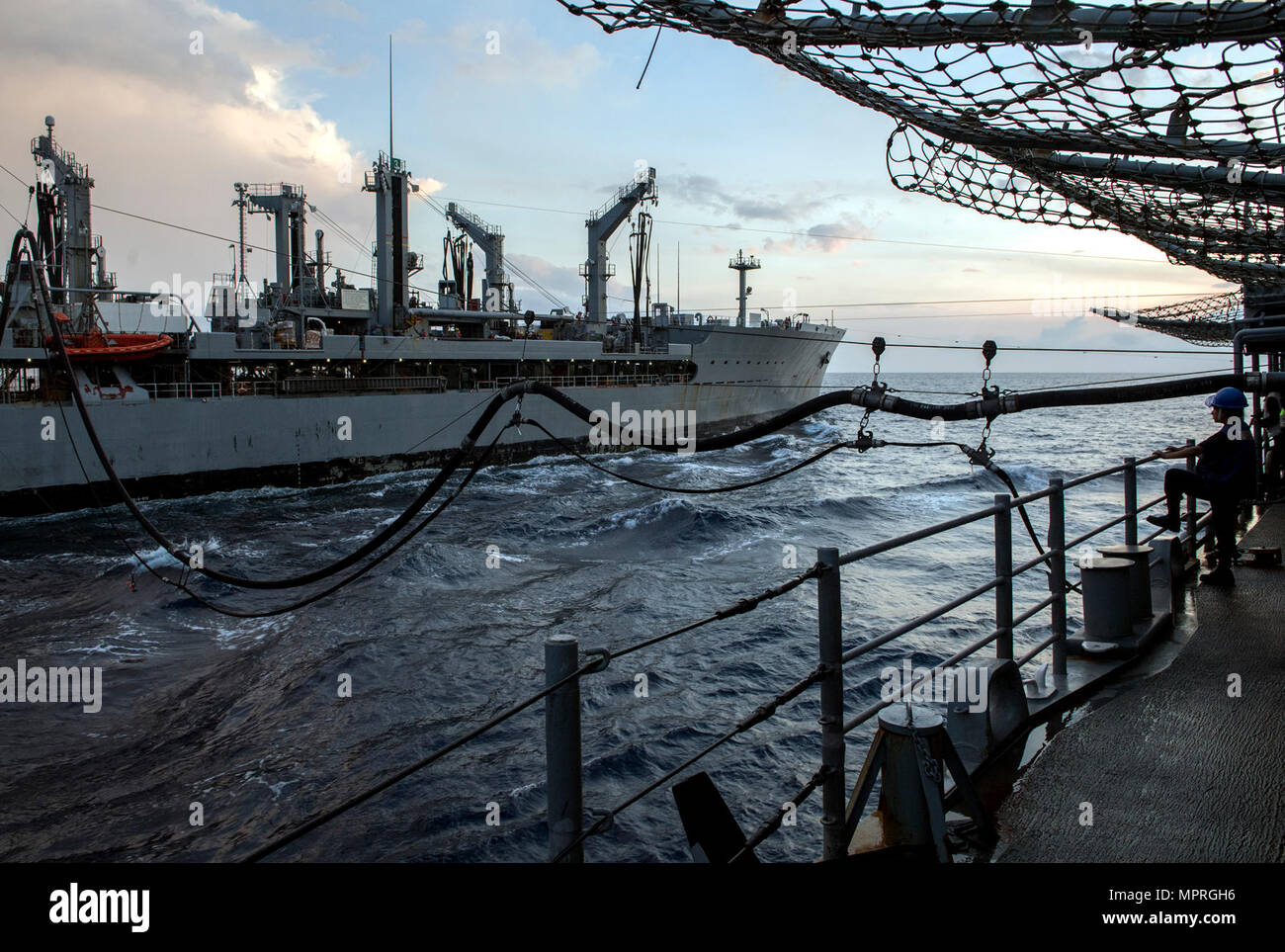 170411-N-FT178-013 SOUTH CHINA SEA (April 11, 2017) Boatswain’s Mate Seaman Athalia Chavez, from Bakersfield, California, observes a replenishment-at-sea with fleet replenishment oiler USNS Pecos (T-AO 197) aboard Ticonderoga-class guided-missile cruiser USS Lake Champlain (CG 57). Lake Champlain is on a regularly scheduled Western Pacific deployment with the Carl Vinson Carrier Strike Group as part of the U.S. Pacific Fleet-led initiative to extend the command and control functions of the U.S. 3rd Fleet in the Indo-Asia-Pacific region. Navy aircraft carrier strike groups have patrolled the In Stock Photo