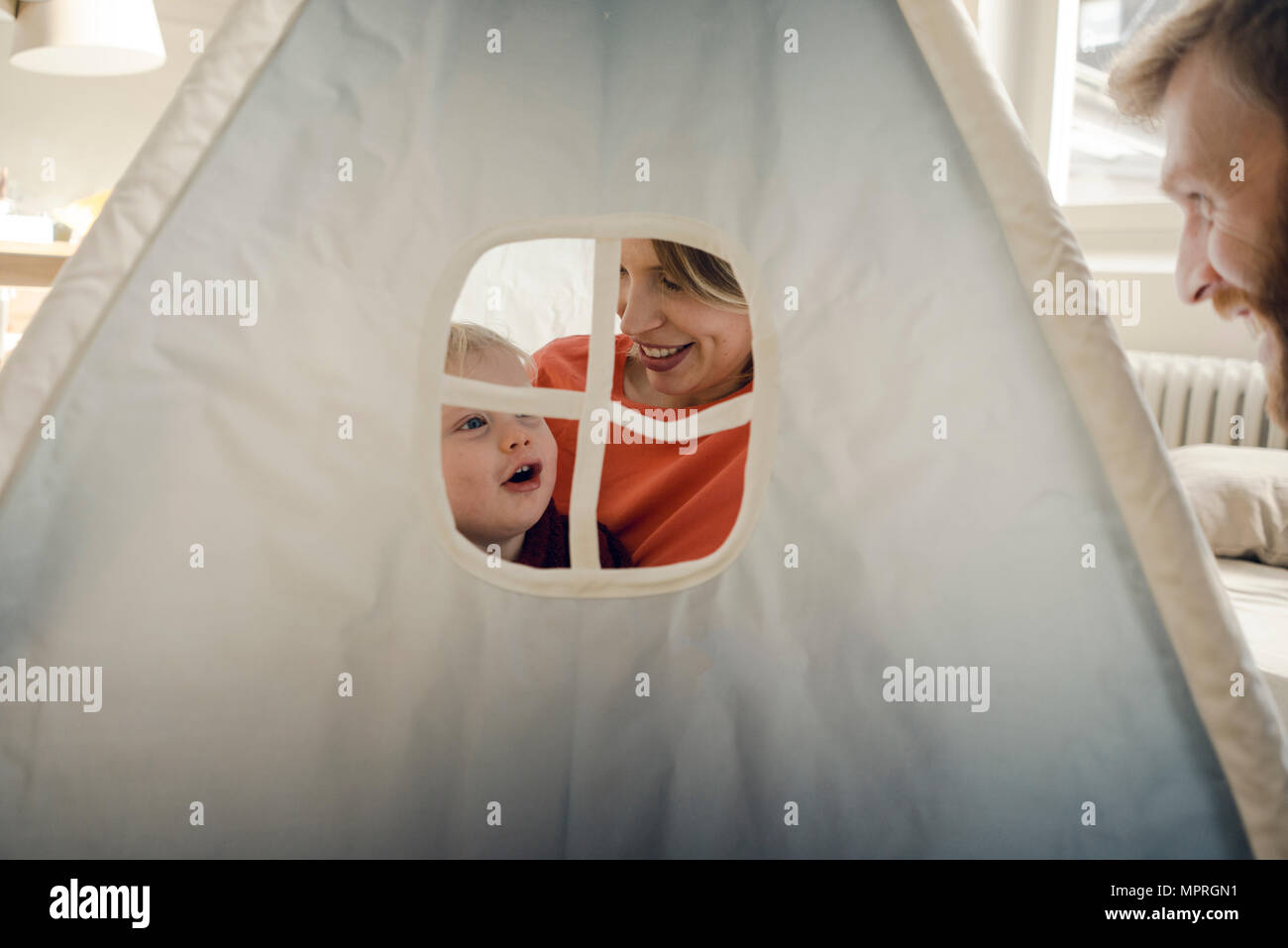 Happy family playing in a tent at home Stock Photo