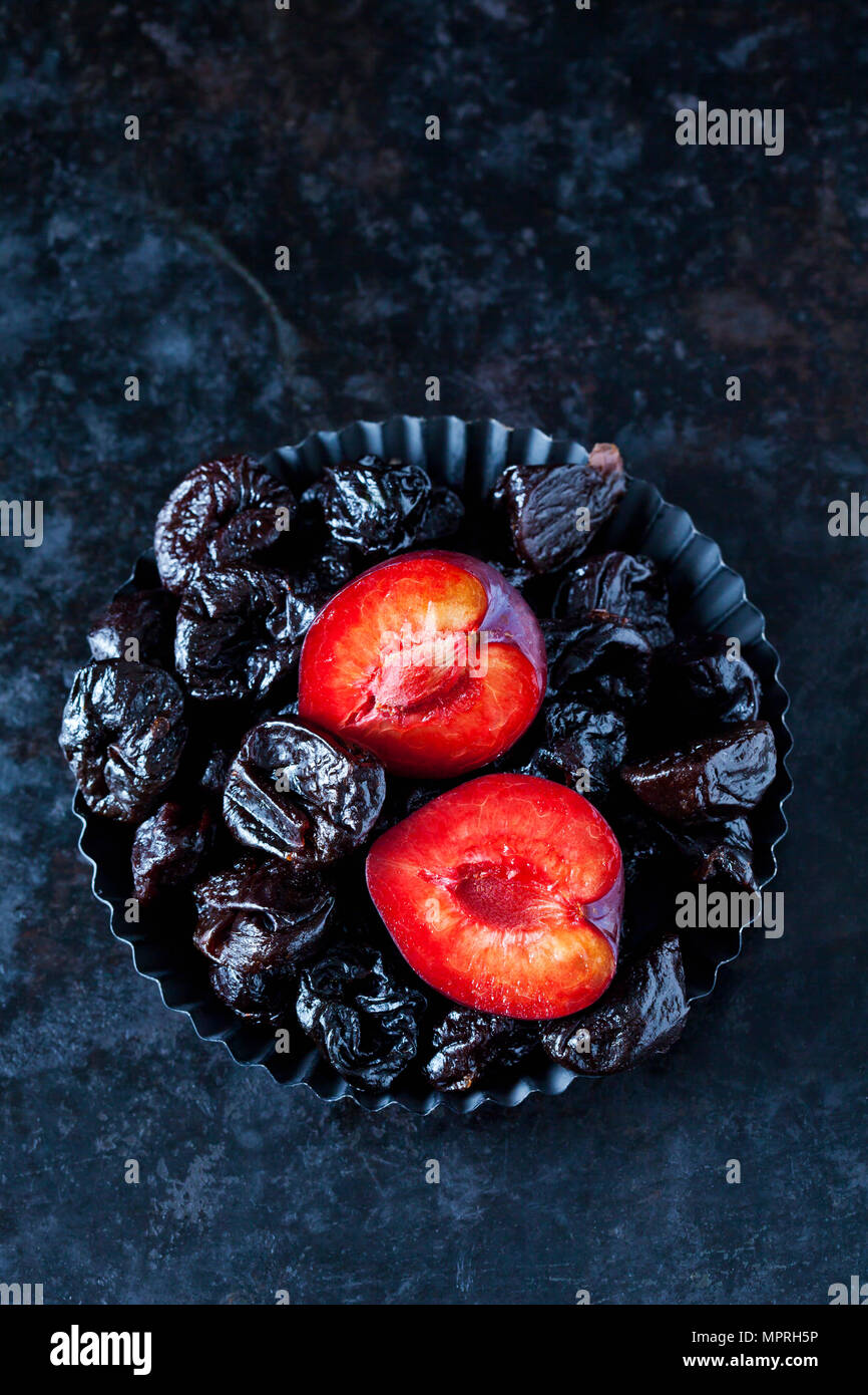 Fresh and dried plums in cake tin Stock Photo