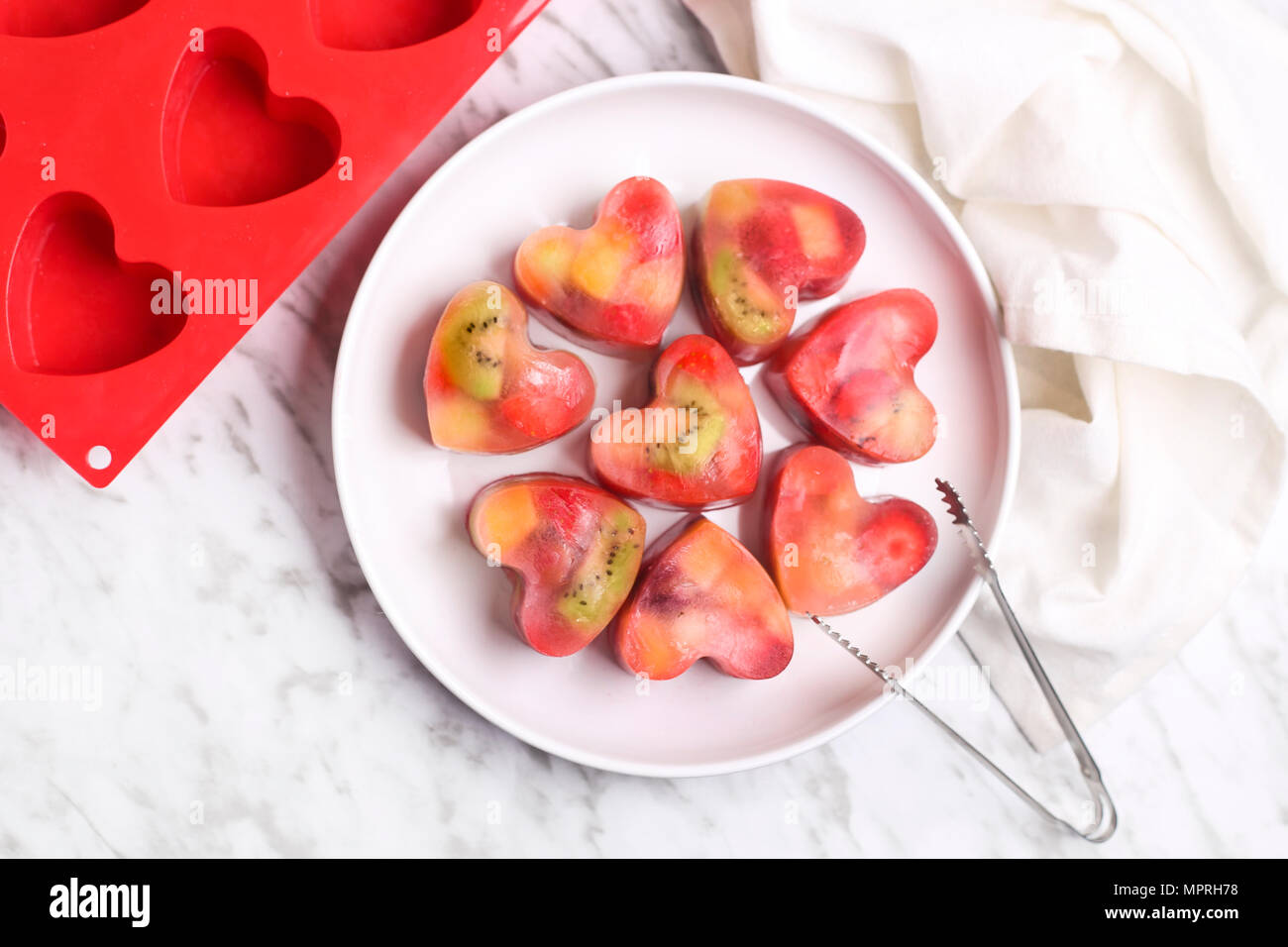 Homemade heart-shaped ice cubes on plate Stock Photo