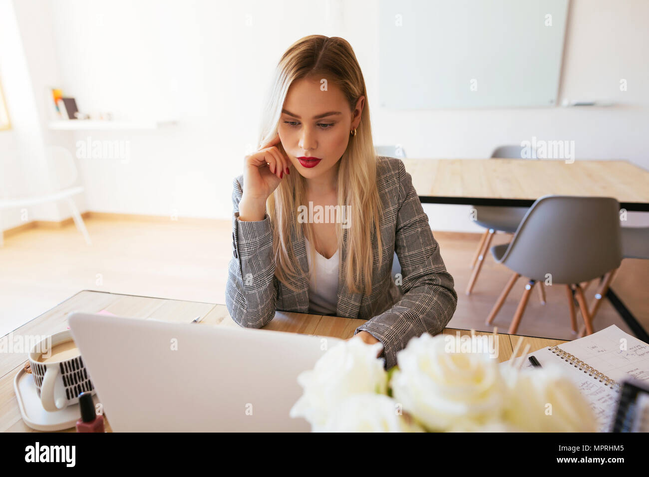Young businesswoman working in office, using laptop Stock Photo