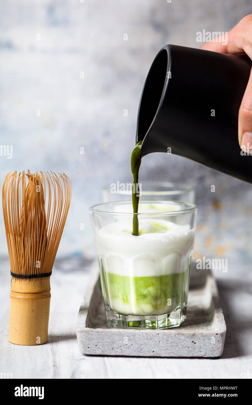 Matcha Latte, pouring matcha tea in a glass Stock Photo