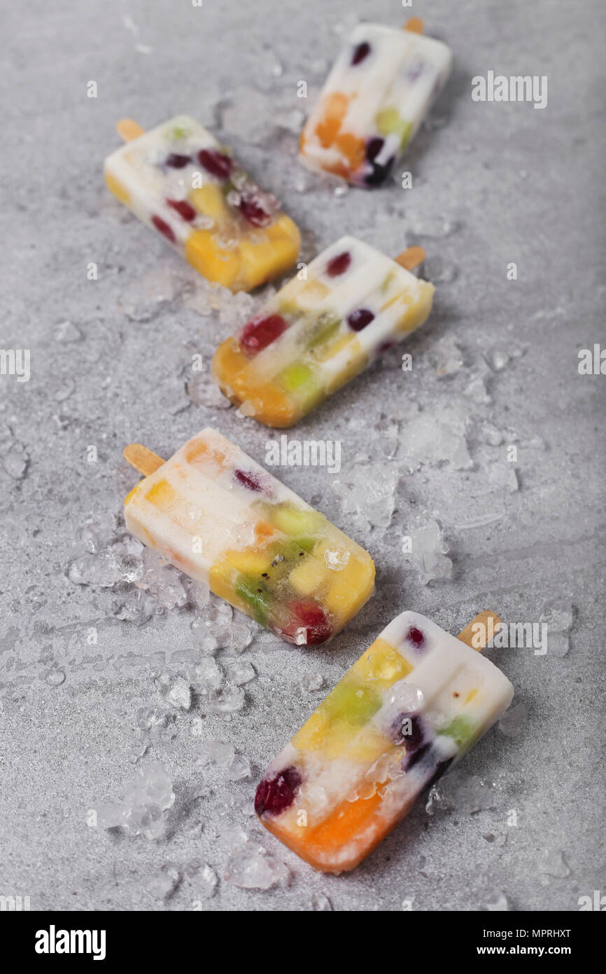 Homemade fruits and yogurt ice lollies on marble Stock Photo