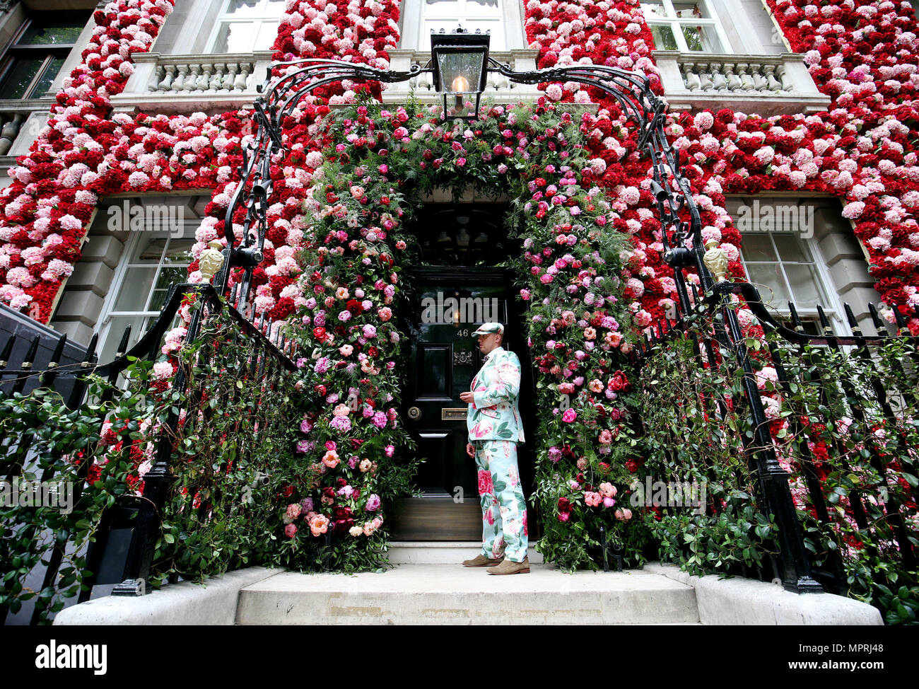 A doorman dressed in a floral patterned suit stands before the entrance to Annabel's in Berkeley Square, London. Stock Photo