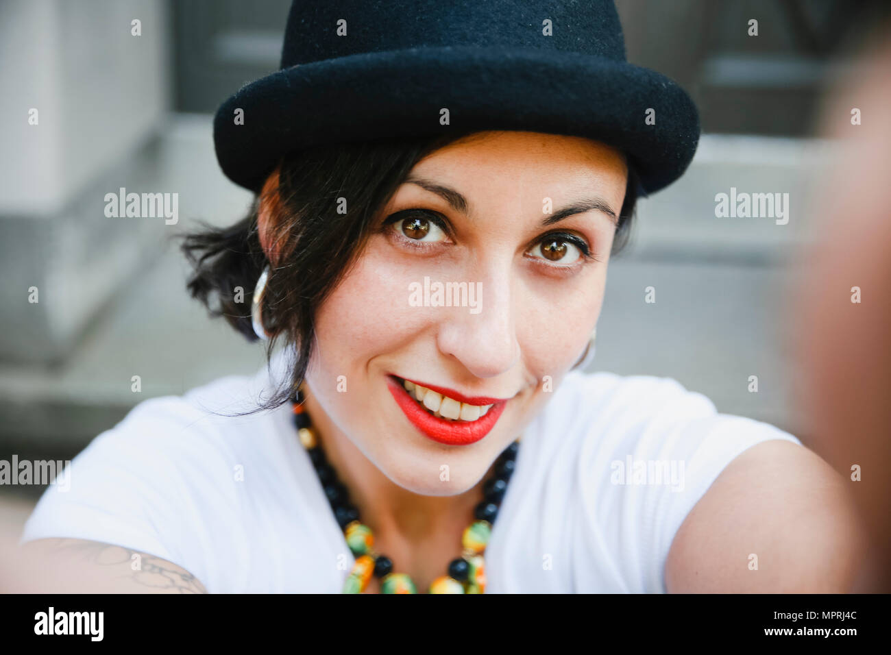 Portrait of smiling woman with hat taking selfie Stock Photo