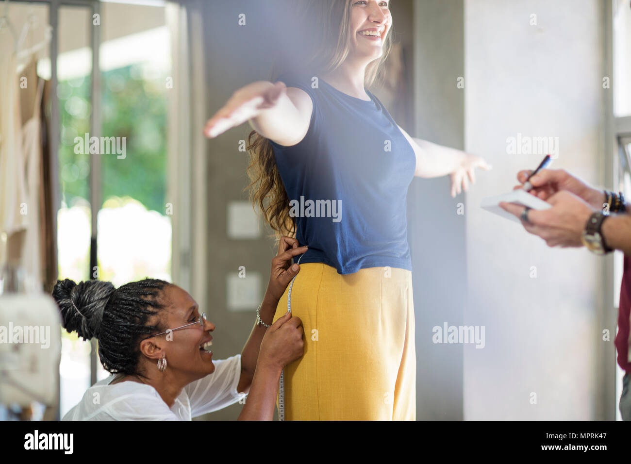 Happy tailor taking measurements Stock Photo