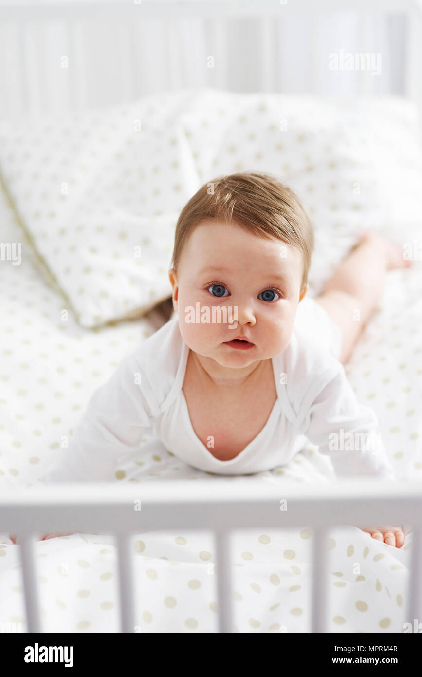 Portrait of baby lying in crib Stock Photo