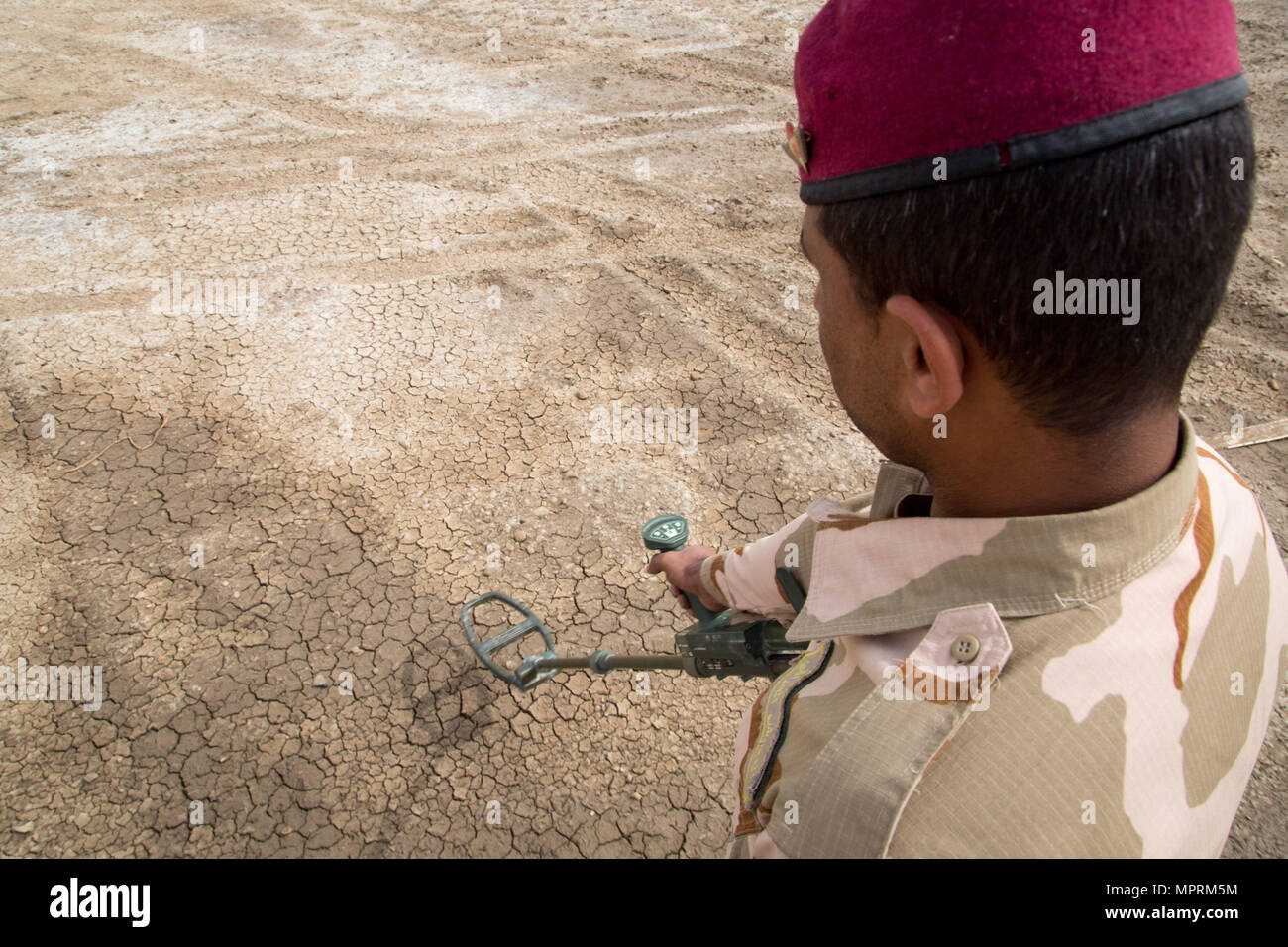 An Iraqi security forces soldier searches for simulated improvised explosive devices using a mine detector during counter-IED training led by British army trainers deployed in support of Combined Joint Task Force – Operation Inherent Resolve at Camp Taji, Iraq, April 12, 2017. This training is part of the overall Combined Joint Task Force – Operation Inherent Resolve building partner capacity mission by training and improving the capability of partnered forces fighting ISIS. CJTF-OIR is the global Coalition to defeat ISIS in Iraq and Syria.  (U.S. Army photo by Spc. Christopher Brecht) Stock Photo
