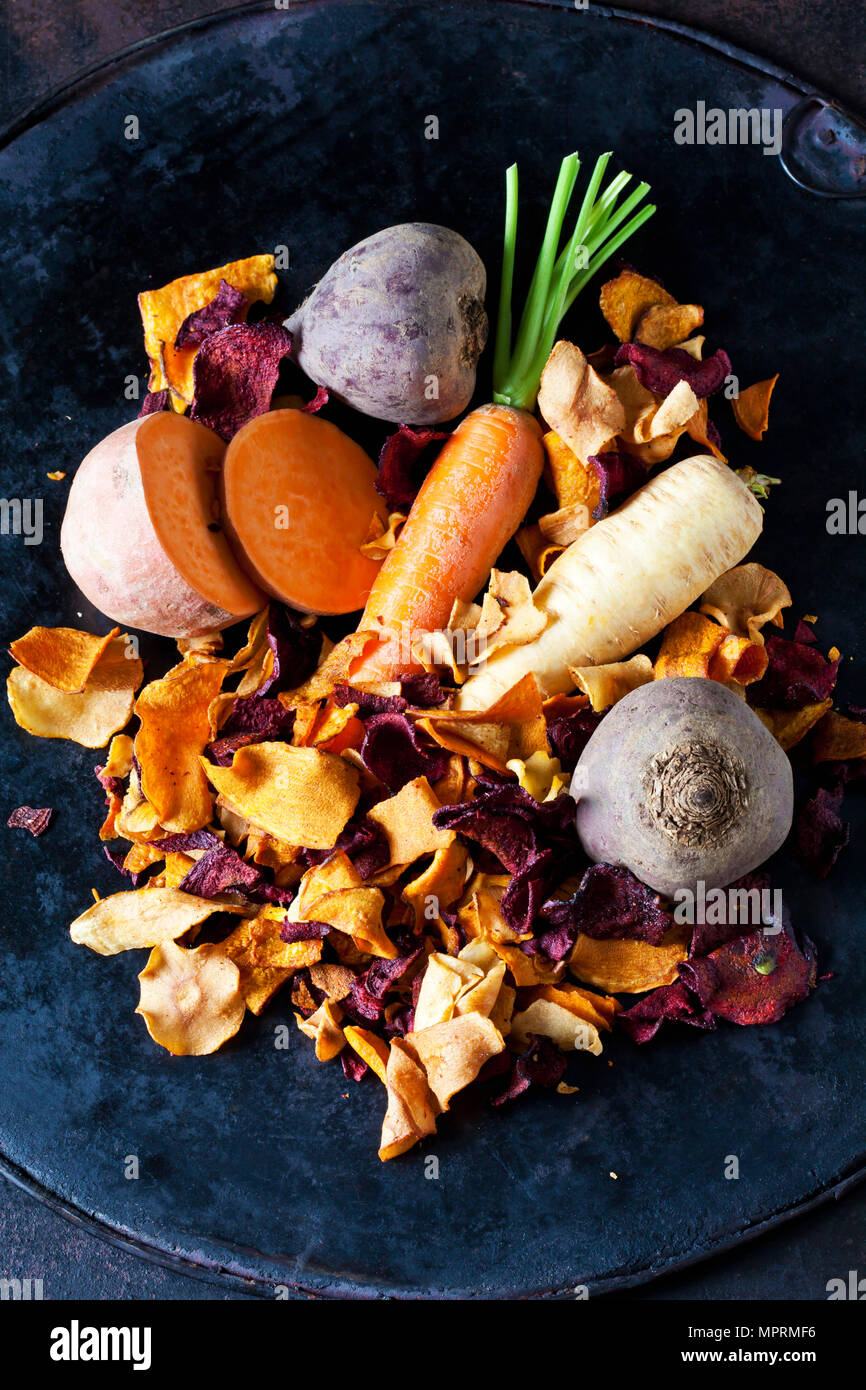 Sliced root vegetables and vegetable chips in bowl Stock Photo