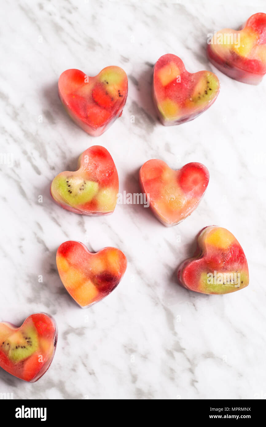 Homemade heart-shaped ice cubes on marble Stock Photo