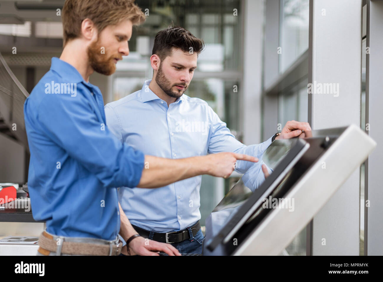 Two businessmen in company using touchscreen Stock Photo
