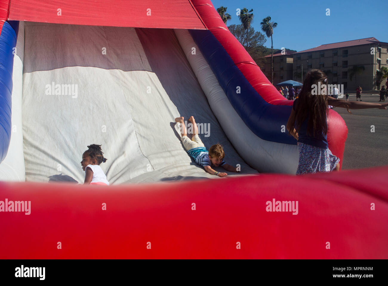 children slide down the bouncy obstacle course slide during the 1st