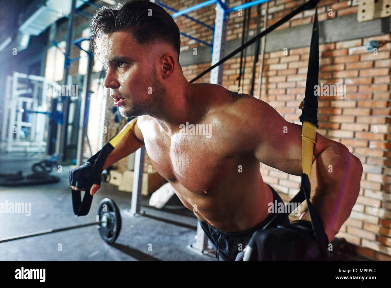 Man doing exercise with suspension straps in gym Stock Photo Alamy