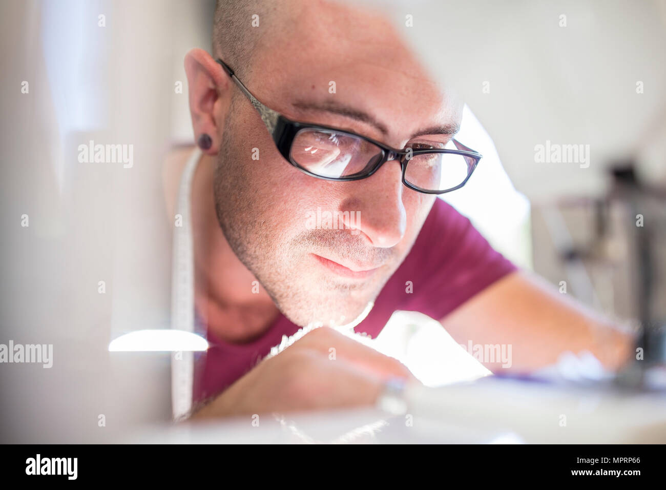 Close-up of man using sewing machine Stock Photo