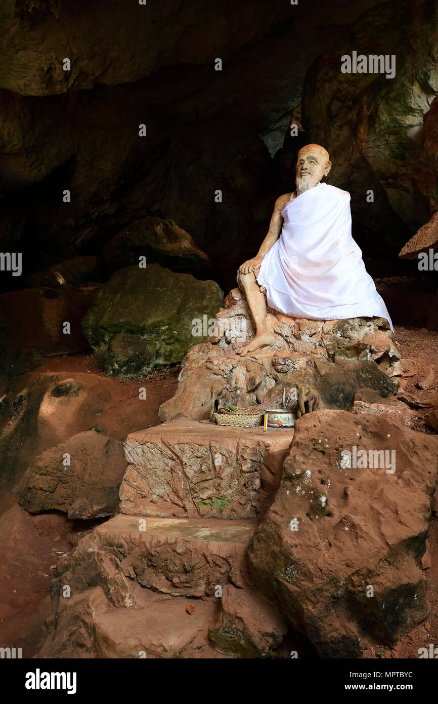 Sitting statue of a monk in the cave temple Wat Tham Suwan Khuha, Phang Nga, Thailand Stock Photo